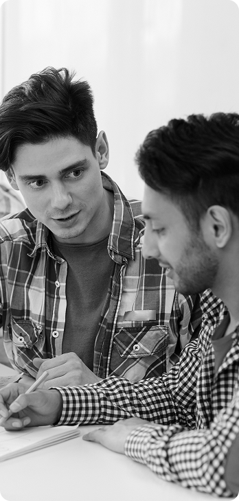 Two young men in discussion, one wearing plaid shirt and another in checkered shirt